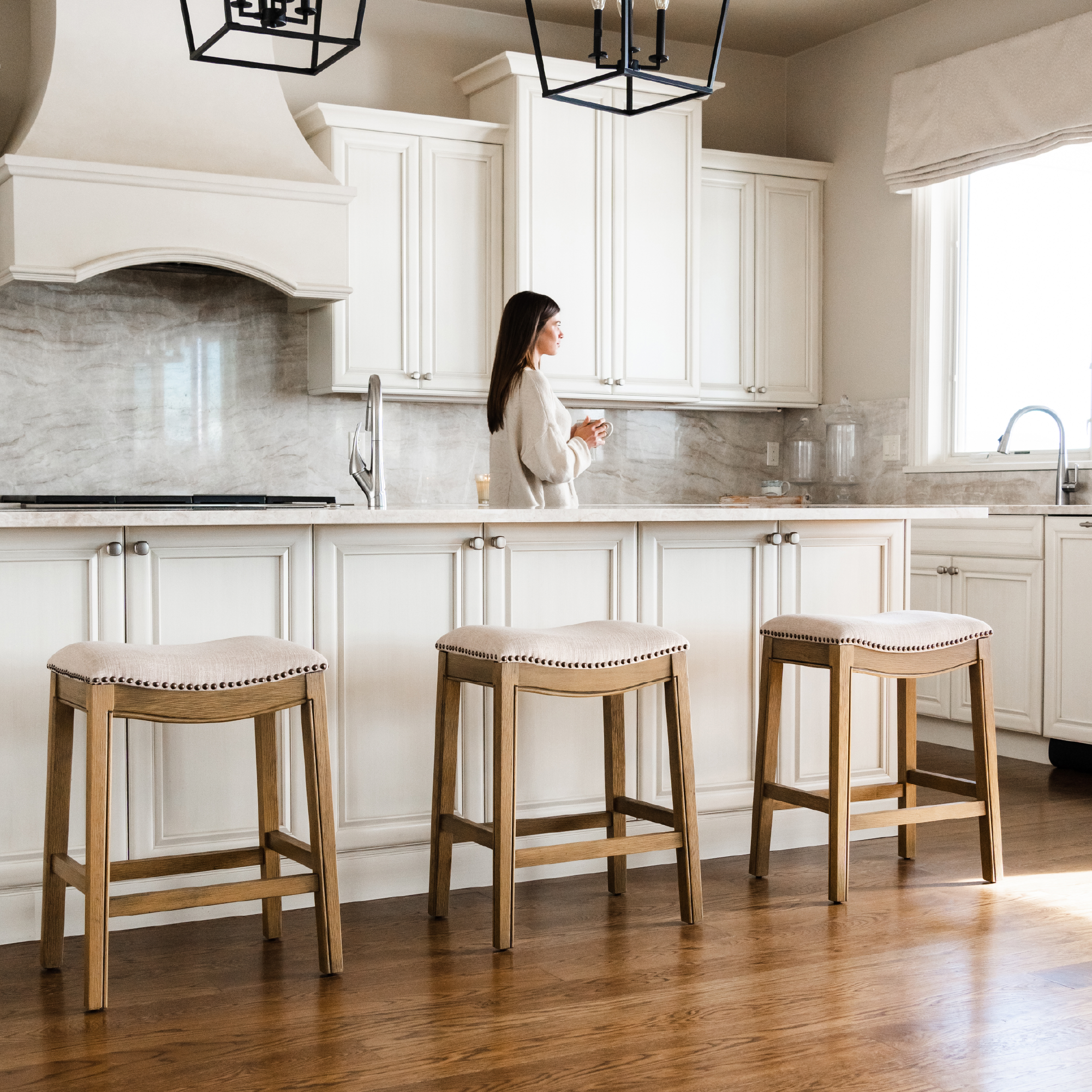 Adrien Saddle Counter Stool in Light Brown Finish and Natural Fabric Upholstery in Stools by Maven Lane
