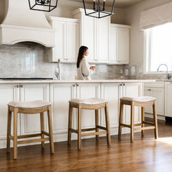 Adrien Saddle Counter Stool in Light Brown Finish and Natural Fabric Upholstery in Stools by Maven Lane