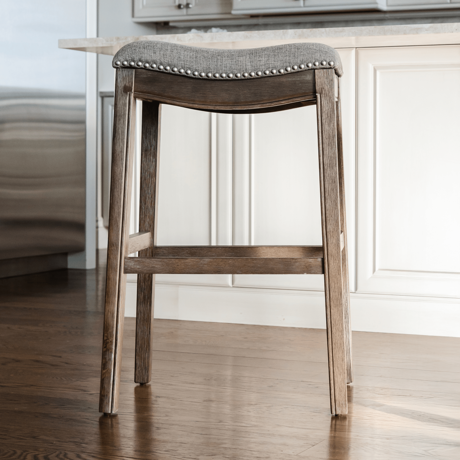 Adrien Saddle Bar Stool in Brown Finish with Grey Fabric in Stools by Maven Lane
