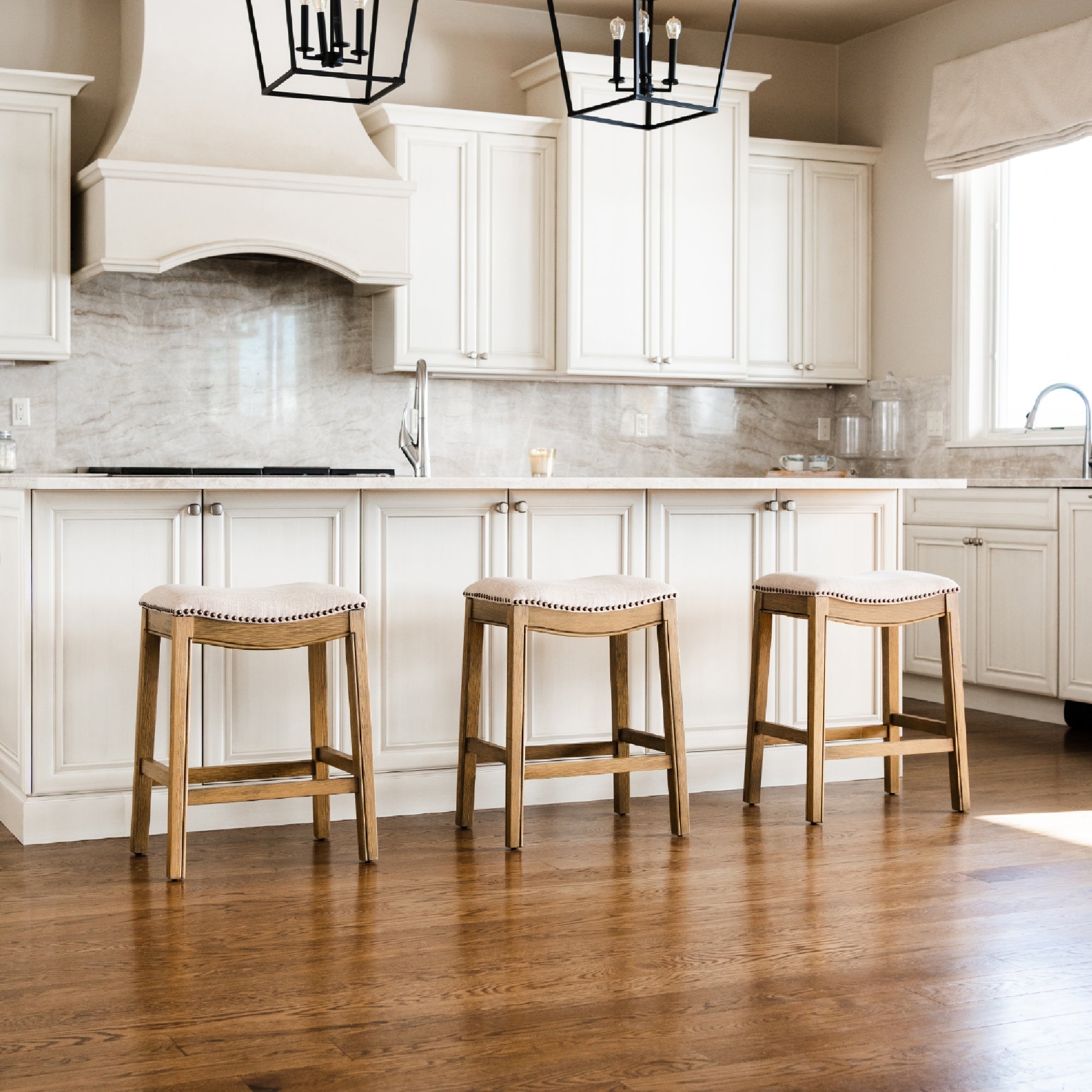 Adrien Saddle Counter Stool in Light Brown Finish and Natural Fabric Upholstery in Stools by Maven Lane