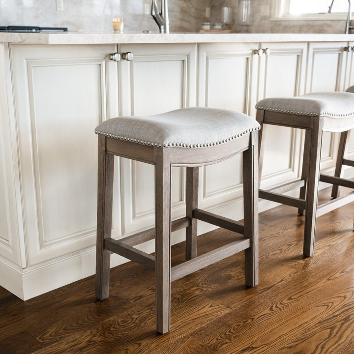 Adrien Saddle Counter Stool In Reclaimed Oak Finish With Ash Grey Fabric Upholstery in Stools by Maven Lane