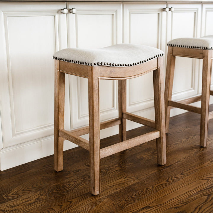 Adrien Saddle Counter Stool In Weathered Oak Finish With Sand Color Fabric Upholstery in Stools by Maven Lane