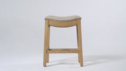 Adrien Saddle Counter Stool in Light Brown Finish and Natural Fabric Upholstery in Stools by Maven Lane
