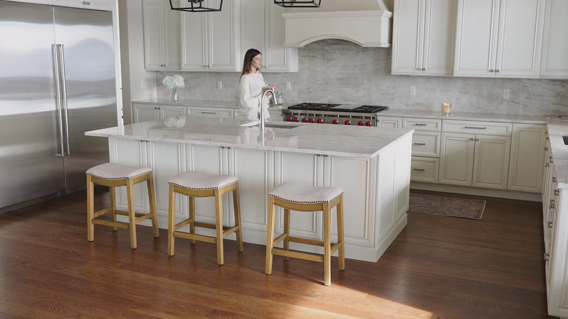 A short video featuring the Adrien Saddle Bar Stool with a Natural Finish in a kitchen setting.